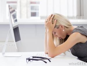 stressed-woman-with-blonde-hair-with-hands-on-head-near-computer